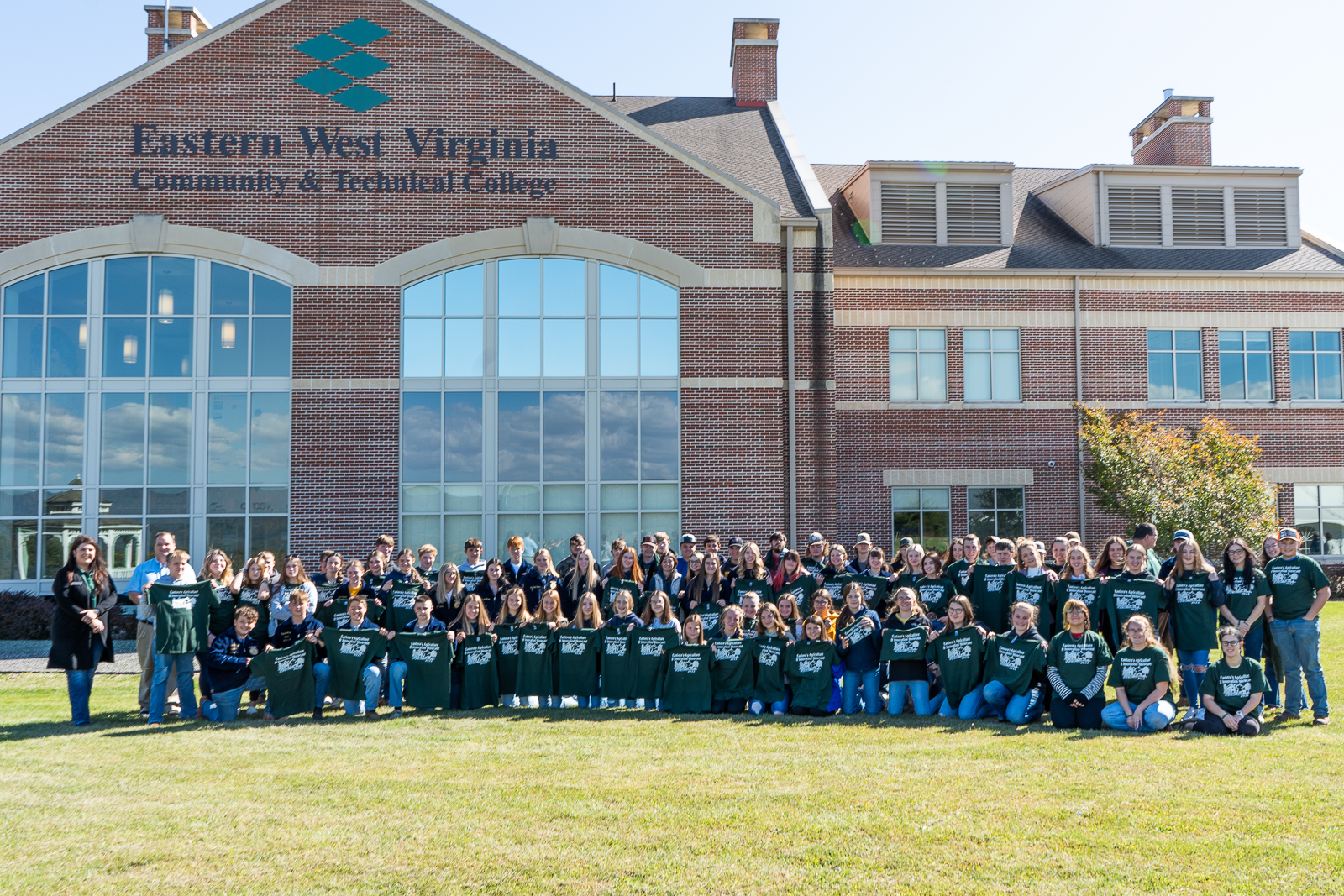 A group of students stand with staff and guests outside the Eastern West Virginia Community and Technical College building.