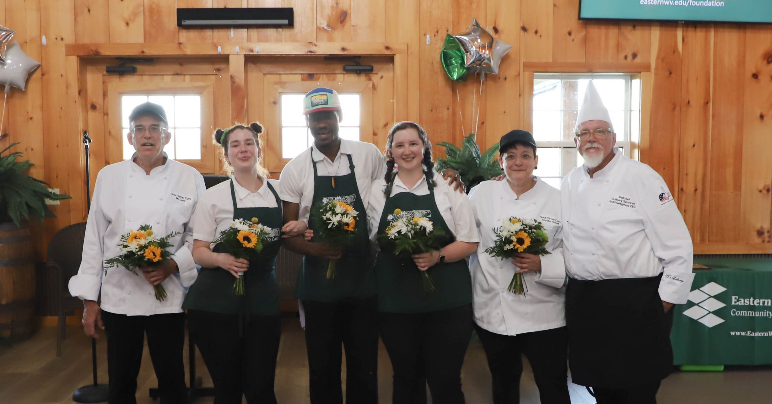 Chef Todd Seligman (far right) stands with his team at the close of the four-course meal. Seligman presented the group with bouquets to thank them for the many hours the team had devoted to the dinner.