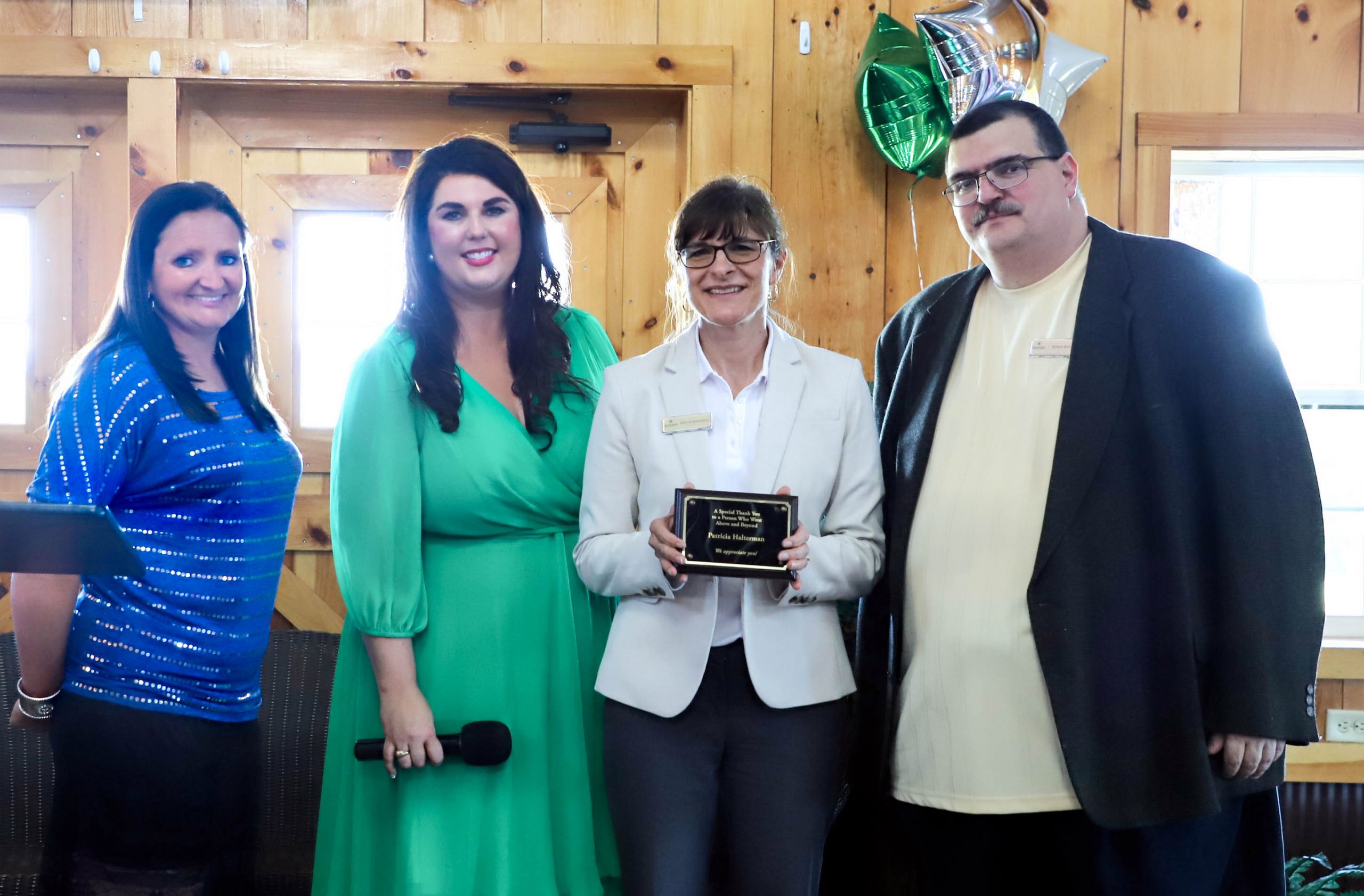 Patricia "Trish" Halterman (holding plaque) was honored for her service with the Farm Fellow and Ag Workforce Training programs at Eastern. With Trish are Carissa Beard (from left), Megan Webb, and Rob Burns.